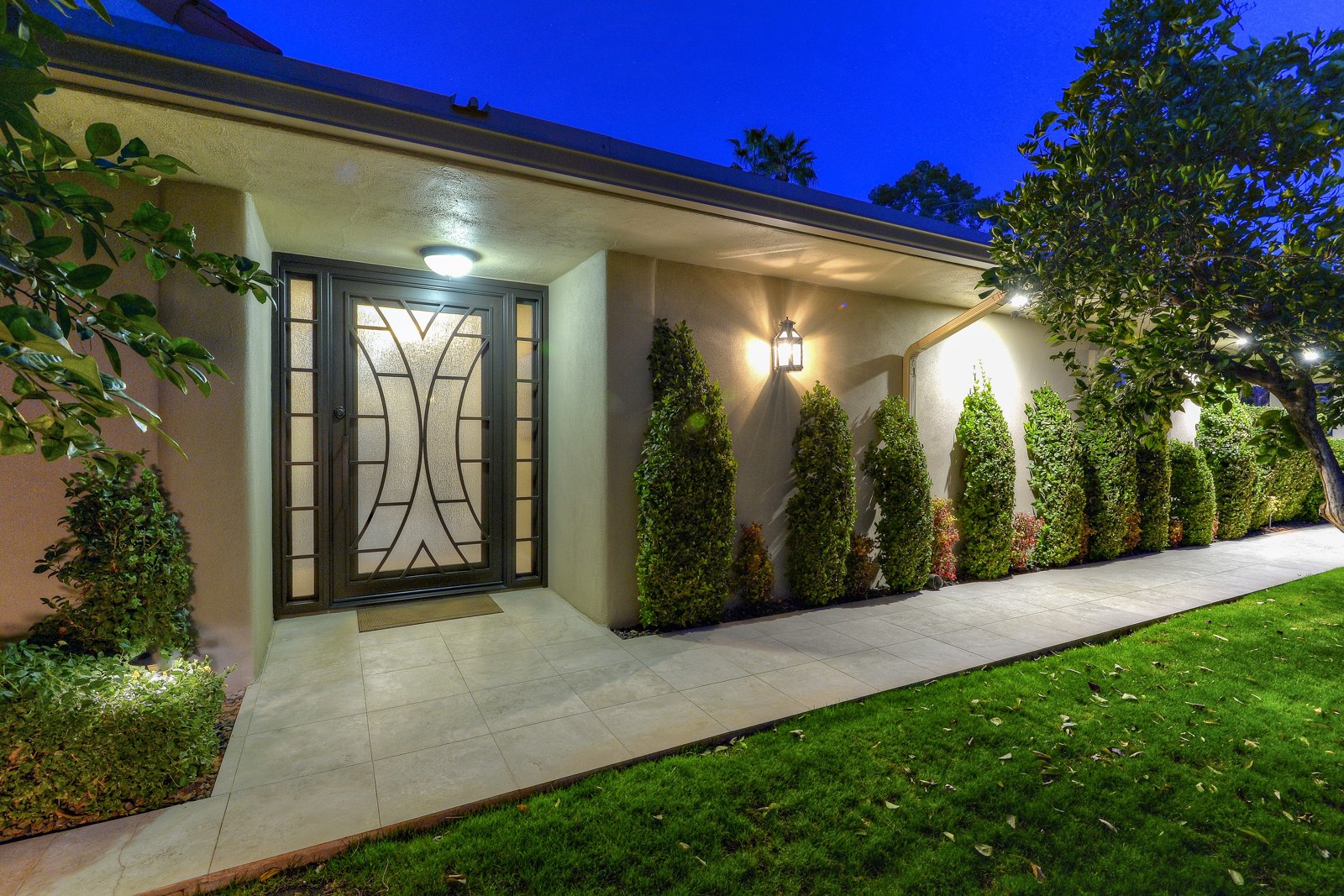 Custom contemporary glass entry door on a McCormick Ranch/Gainey Ranch home at twilight
